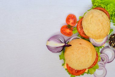 Peynir, et, domates ve soğan ve otlar ile hamburger. Ahşap arka plan üzerinde. Üstten Görünüm. Boş alan.