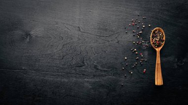 Güzel kokulu baharatlar kümesi. Siyah ve kırmızı biber, kişniş, kırmızı biber karışımı. Ahşap arka plan üzerinde. Üstten Görünüm. Boş alan.