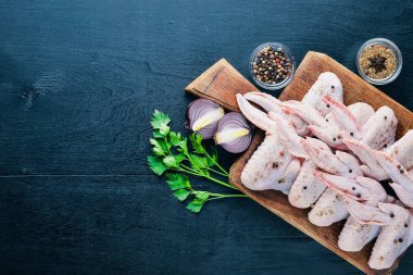 Baharat ile çiğ tavuk kanatları. Ahşap yüzeyde. Üstten Görünüm.