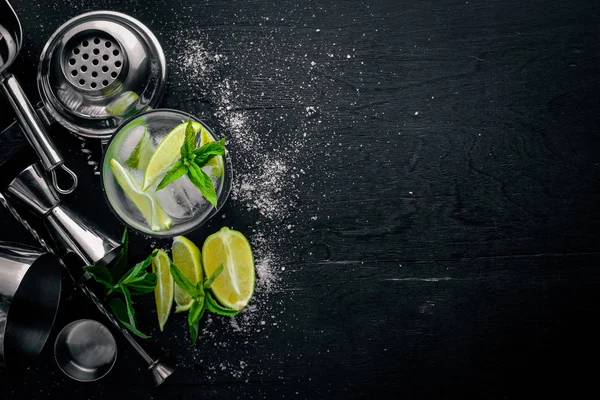 Limon ve nane kokteyli, buz, siyah ahşap yüzeye. Üstten Görünüm. Boş alan.