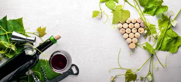 Üzüm cinayet sebebi. Bir şişe, bir bardak şarap ve üzüm yaprakları. Üstten Görünüm. Boş alan.