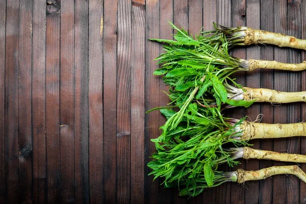 Taze horseradish. Kahverengi ahşap tablo. Üstten Görünüm.