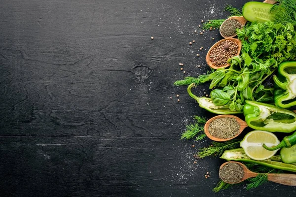 Yeşil sebzeler ve baharat ahşap arka plan üzerinde büyük bir seçim. Üstten Görünüm. Boş alan.