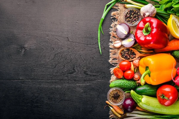 Rám z biopotravin. Čerstvá syrová zelenina a koření. Na dřevěné tabuli. — Stock fotografie
