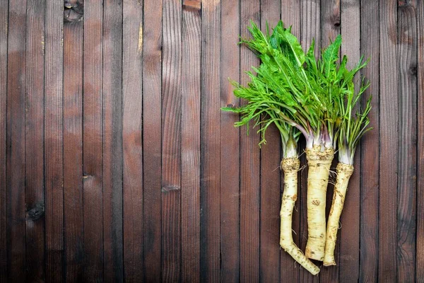 Taze horseradish. Kahverengi ahşap tablo. Üstten Görünüm.