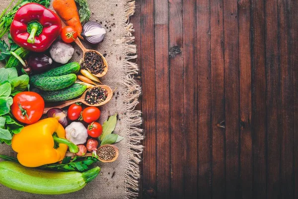 Рамка из органических продуктов питания. Свежие сырые овощи и специи. На деревянной доске . — стоковое фото
