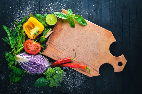 Taze sebze. Yemek pişirmek için hazırlanıyor. Siyah ahşap arka plan üzerinde. Üstten Görünüm. Metin için boş alan.
