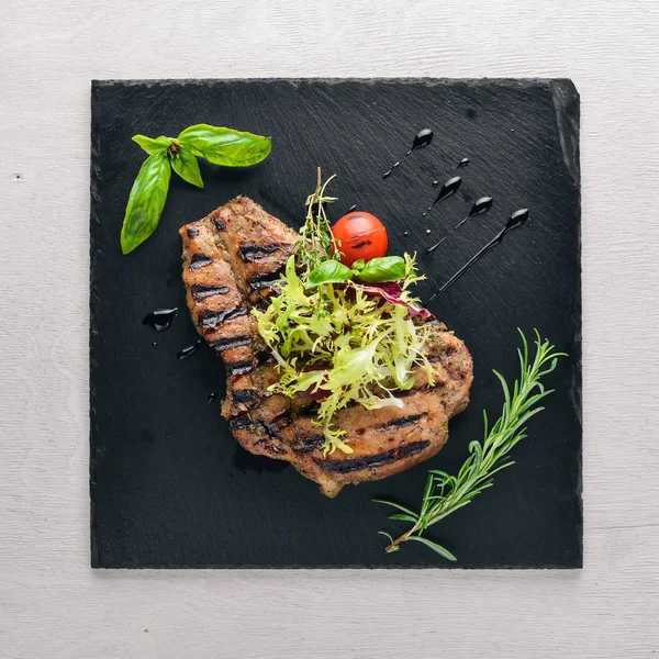 Dana biftek ızgarada pişirilir. Ahşap bir arka plan üzerinde. En iyi bir daha gözden geçirme. Boş alan.