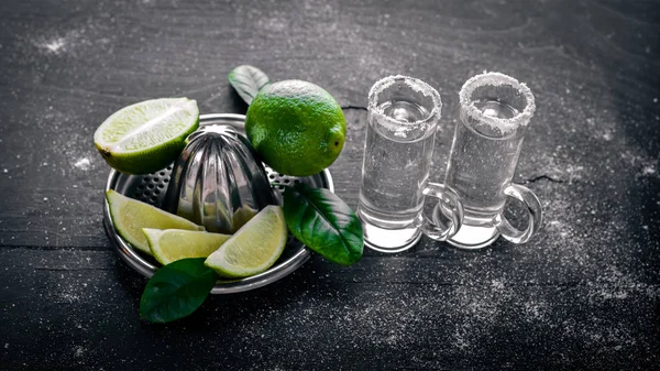 Tequila with lime, lemon, and salt on a black background Wooden. Free space for text . Top view. — Stock Photo, Image