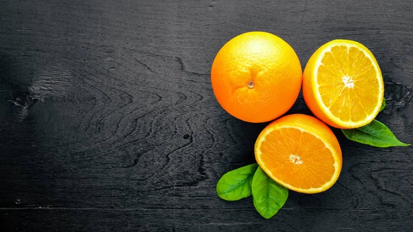 Taze narenciye. Turuncu. Bir siyah arka plan üzerine tahta. Üstten Görünüm.