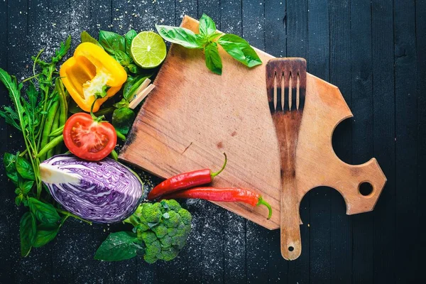 Taze sebze. Yemek pişirmek için hazırlanıyor. Siyah ahşap arka plan üzerinde. Üstten Görünüm. Metin için boş alan.