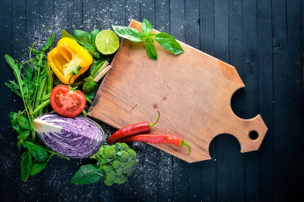 Taze sebze. Yemek pişirmek için hazırlanıyor. Siyah ahşap arka plan üzerinde. Üstten Görünüm. Metin için boş alan.