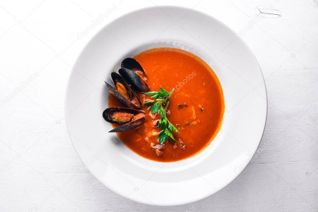 Tomato and seafood creamy soup with mussels. On a wooden background. Top view. Free space for your text.