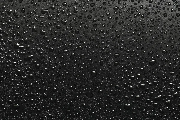 Drops of water on a black surface — Stock Photo, Image