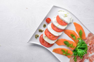 Domates ve mozzarella peyniri ile carpaccio. Ahşap bir arka plan üzerinde. Üstten Görünüm. Metin için boş alan.
