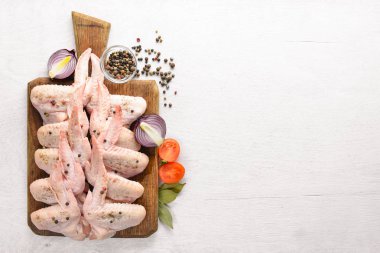 Baharat ile çiğ tavuk kanatları. Ahşap yüzeyde. Üstten Görünüm.