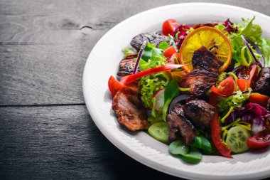 Salata taze salatalık, domates ve yeşillik bir plaka ahşap tahta üzerinde ızgara et ile. Üstten Görünüm. Boş alan.