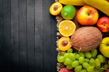 Siyah ahşap bir masa üzerine taze meyve büyük kümesi. Metniniz için boş alan. Üstten Görünüm.