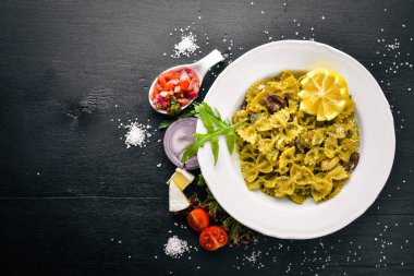 Ispanak, zeytin ve parmesan peyniri ile mantarlı makarna. İtalyan yemeği. Bir siyah ahşap yüzeye. Metniniz için boş alan. Üstten Görünüm.