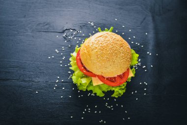 Peynir, et, domates ve soğan ve otlar ile hamburger. Ahşap arka plan üzerinde. Üstten Görünüm. Boş alan.