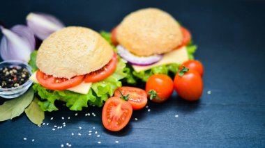 Peynir, et, domates ve soğan ve otlar ile hamburger. Ahşap arka plan üzerinde. Üstten Görünüm. Boş alan.