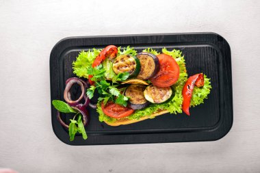 Bruschetta ızgara sebze, zeytin, otlar ve parmesan peyniri ekmeğin. Soğuk aperatifler. İtalyan mutfağı. Ahşap arka plan üzerinde.