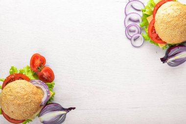 Peynir, et, domates ve soğan ve otlar ile hamburger. Ahşap arka plan üzerinde. Üstten Görünüm. Boş alan.