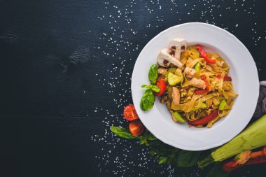 Makarna tavuk fileto, parmesan peyniri ve mantar ve fesleğen. Bir siyah ahşap yüzeye. Metniniz için boş alan. Üstten Görünüm.