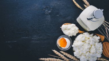 Süt ve süt ürünleri. Peynir, peynir, süt, ekşi krema, siyah ahşap zemin. Üstten Görünüm. Boş alan.