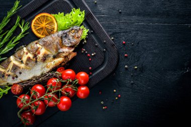 Alabalık balık pişmiş aromatik otlar ve baharatlar ile. Ahşap arka plan üzerinde.