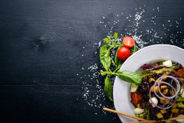 Izgara sebze salatası, mantar, beyaz peynir ve zeytin yağı. Bir siyah ahşap yüzeye. Metniniz için boş alan. Üstten Görünüm.