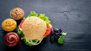 Ahşap arka plan üzerinde peynir, et ve yeşil soğan ile hamburger. Üstten Görünüm. Boş alan.