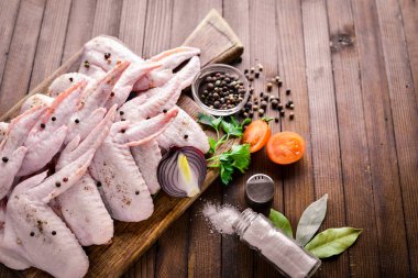 Baharat ile çiğ tavuk kanatları. Ahşap yüzeyde. Üstten Görünüm.