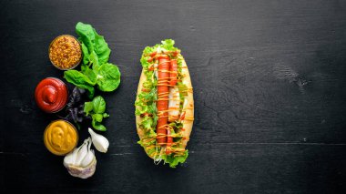 Sosisli otlar ve Baharatlar, hardal ve ketçap. Ahşap arka plan üzerinde. Üst alanı ile ilgilenen.