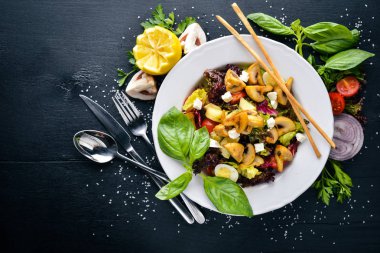 Izgara sebze salatası, mantar, beyaz peynir ve zeytin yağı. Bir siyah ahşap yüzeye. Metniniz için boş alan. Üstten Görünüm.