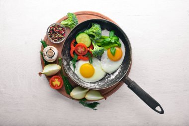 Sahanda yumurta ile bir tavada sebze ve otlar. Üstten Görünüm. Boş alan.