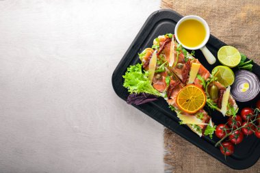 Somon Bruschetta otlar ve parmesan peyniri ekmeğin. Soğuk aperatifler. İtalyan mutfağı. Ahşap arka plan üzerinde.