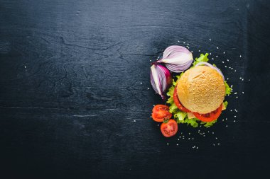 Peynir, et, domates ve soğan ve otlar ile hamburger. Ahşap arka plan üzerinde. Üstten Görünüm. Boş alan.