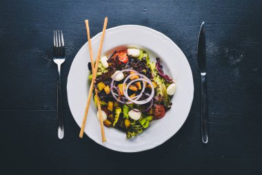 Izgara sebze salatası, mantar, beyaz peynir ve zeytin yağı. Bir siyah ahşap yüzeye. Metniniz için boş alan. Üstten Görünüm.