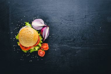 Peynir, et, domates ve soğan ve otlar ile hamburger. Ahşap arka plan üzerinde. Üstten Görünüm. Boş alan.