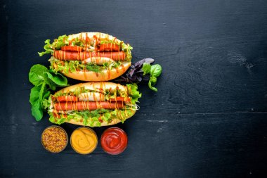 Sosis ızgara sosis, hardal ve ketçap, soğan ve Yeşiller ahşap arka plan üzerinde. Üstten Görünüm. Boş alan.