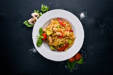 Makarna tavuk fileto, parmesan peyniri ve mantar ve fesleğen. Bir siyah ahşap yüzeye. Metniniz için boş alan. Üstten Görünüm.