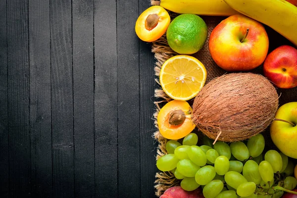 Siyah ahşap bir masa üzerine taze meyve büyük kümesi. Metniniz için boş alan. Üstten Görünüm.