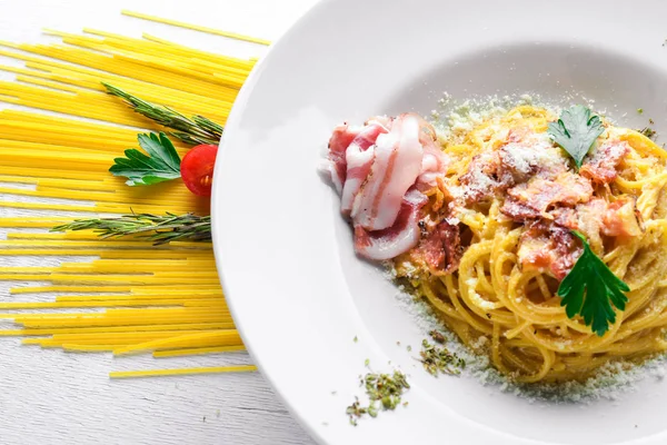 Kremalı sos pastırma ile makarna. Geleneksel İtalyan yemekleri. Ahşap bir arka plan üzerinde. Üstten Görünüm. Metniniz için boş alan.