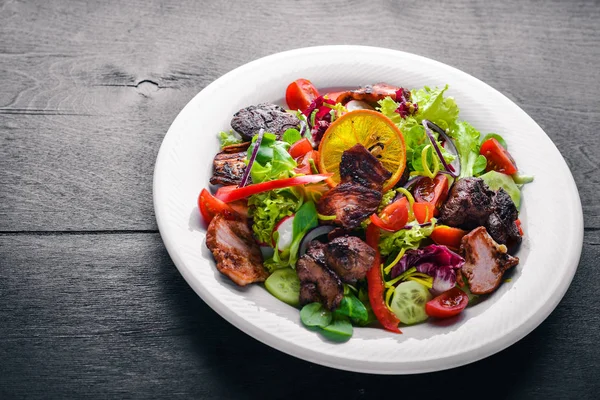 Salata taze salatalık, domates ve yeşillik bir plaka ahşap tahta üzerinde ızgara et ile. Üstten Görünüm. Boş alan.