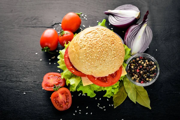 Peynir, et, domates ve soğan ve otlar ile hamburger. Ahşap arka plan üzerinde. Üstten Görünüm. Boş alan.