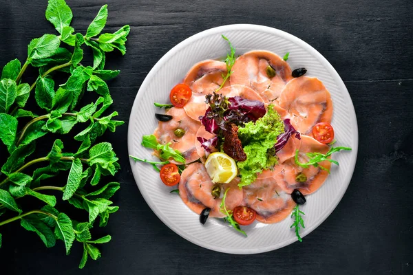 Carpaccio balık, sebze, peynir, baharatlar, ahşap arka plan için. Üstten Görünüm. Boş alan.