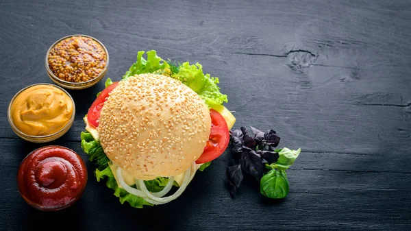 Ahşap arka plan üzerinde peynir, et ve yeşil soğan ile hamburger. Üstten Görünüm. Boş alan.