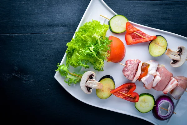 Ham şiş kebap ve taze sebze. Ahşap bir arka plan üzerinde. Üstten Görünüm. FreeSpace metin için.
