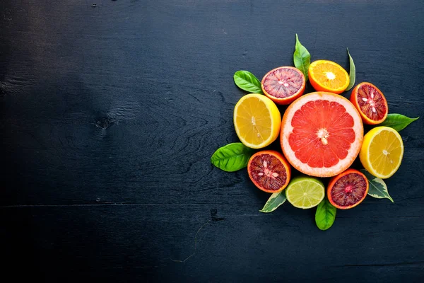 Taze narenciye. Limon portakal, mandalina, limon. Bir siyah arka plan üzerine tahta. Üstten Görünüm.